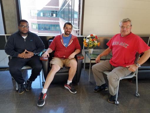 three people sitting in chairs and posing for a photo